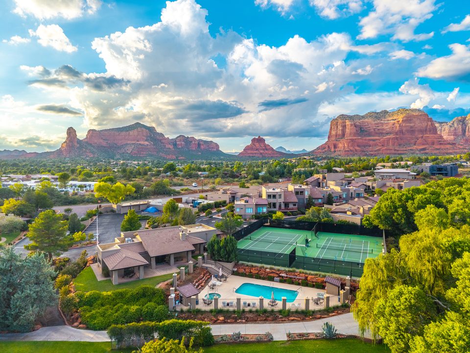 Community courts and pool with red rocks beyond · Aerial photograph