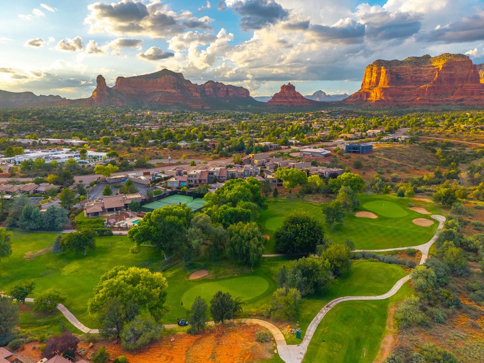 The golf course and its red-rock backdrop in golden light