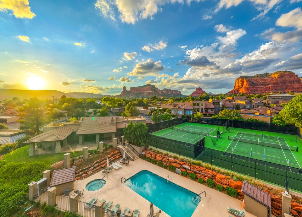 The community pool and tennis courts at sunset, with red rocks beyond
